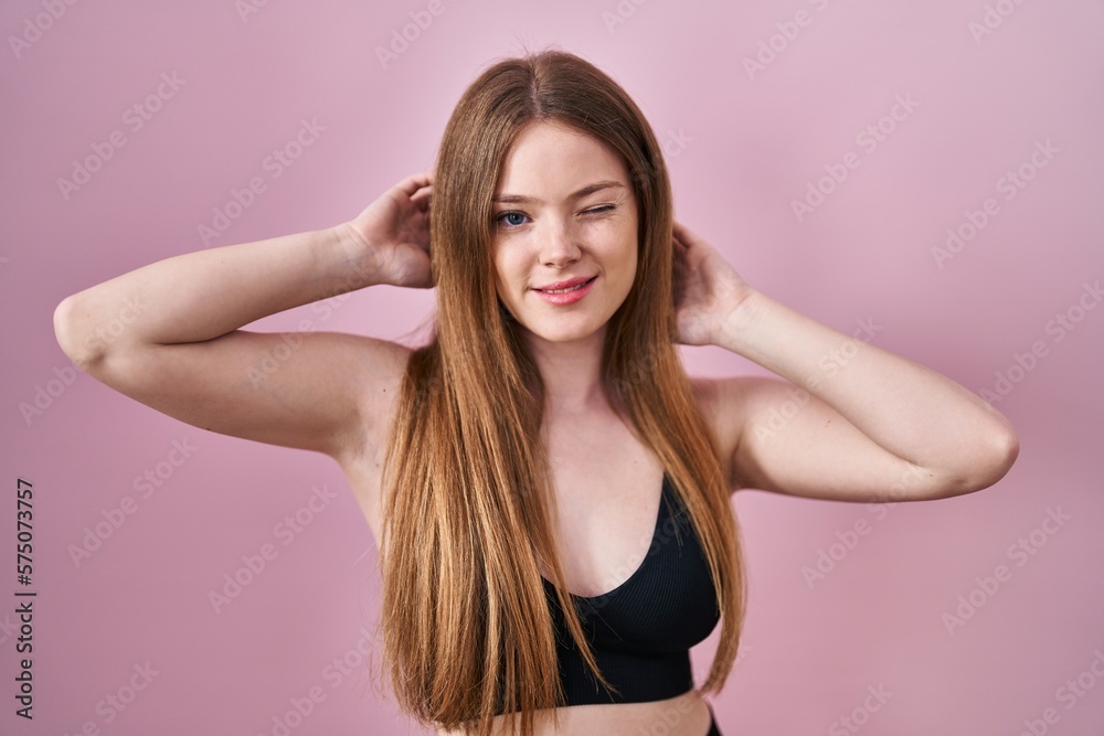 Young caucasian woman wearing lingerie over pink background winking looking at the camera with sexy expression, cheerful and happy face. Young caucasian woman wearing lingerie over pink background winking looking at the camera with sexy expression, cheerful and happy face.