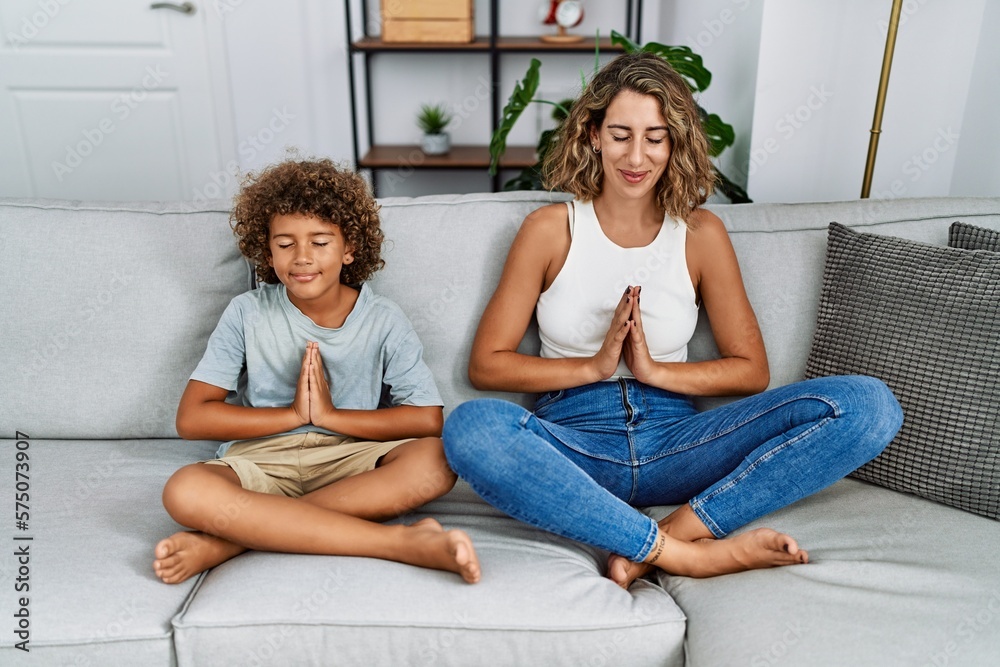 Mother and son meditating doig yoga exercise at home Mother and son meditating doig yoga exercise at home