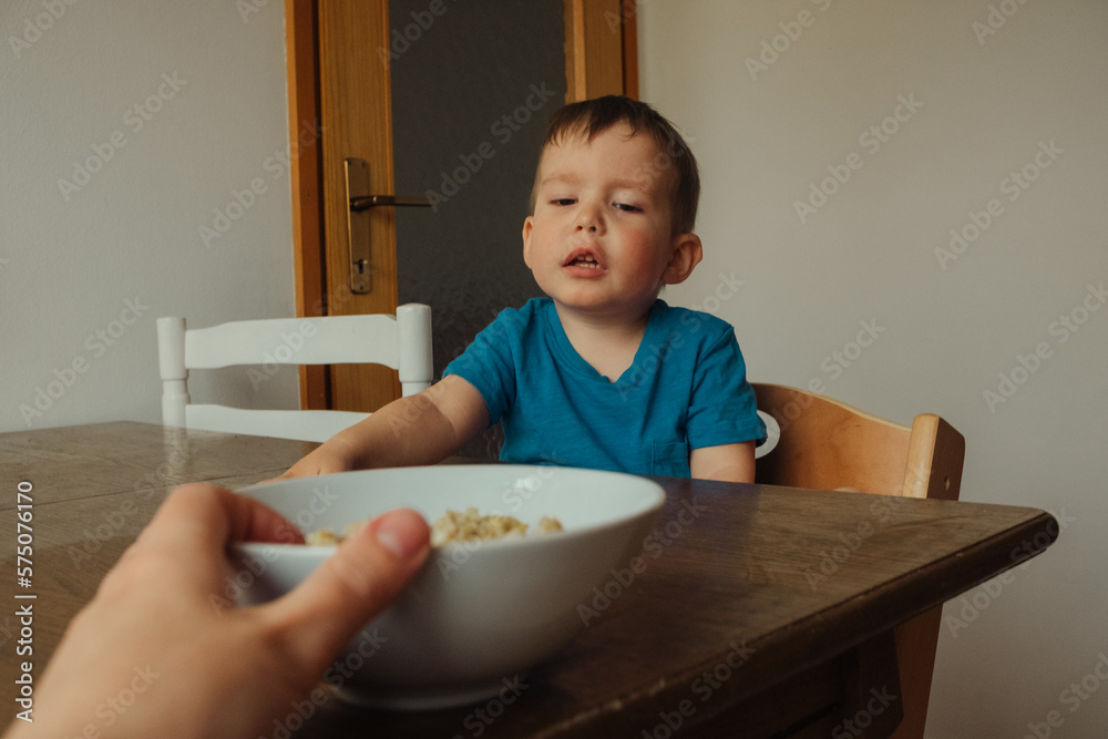 parent gives the child a plate of food for breakfast
parent gives the child a plate of food for breakfast