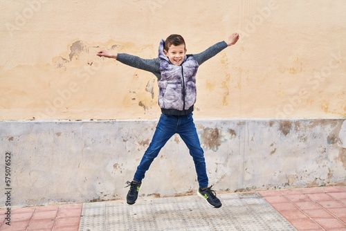 Blond child smiling confident jumping at street © Krakenimages.com