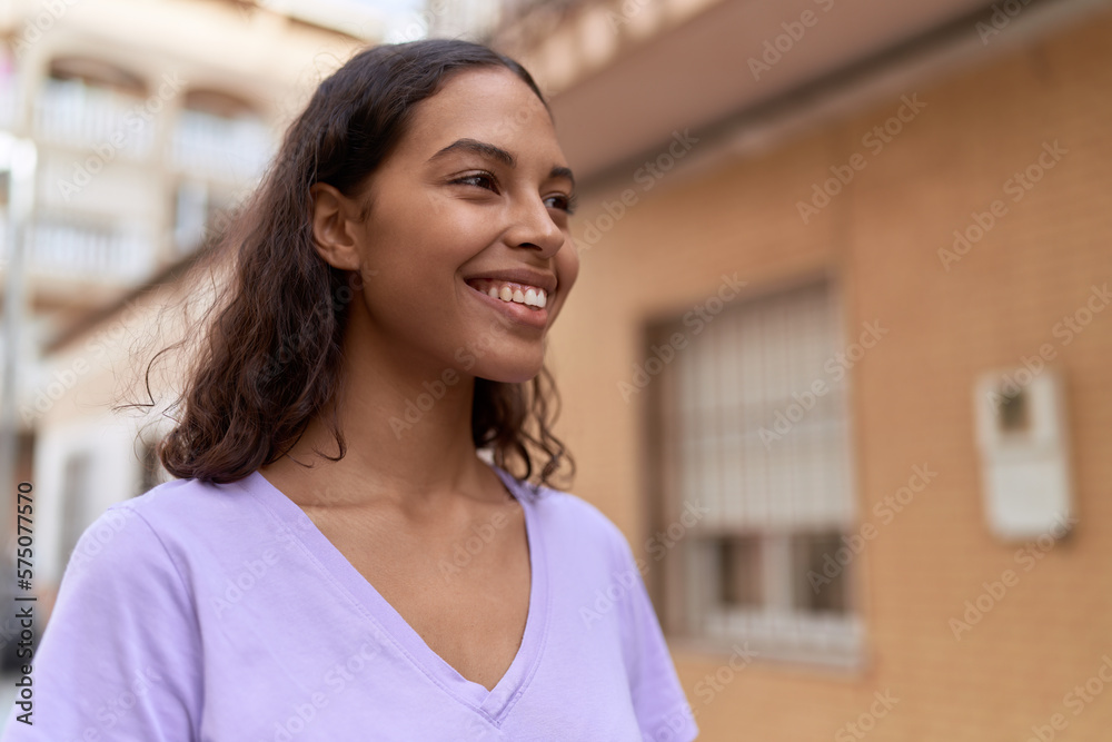 Young african american woman smiling confident looking to the side at street