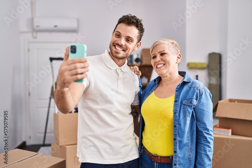 Mother and son make selfie by the smartphone at new home
