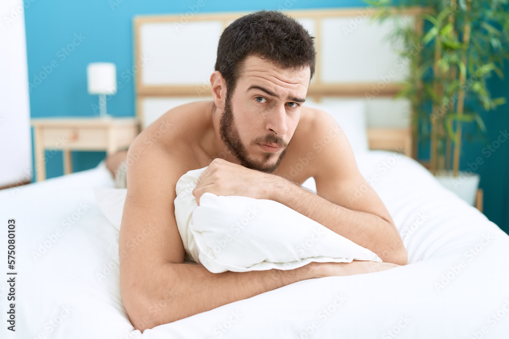 Young hispanic man lying on bed with relaxed expression at bedroom Young hispanic man lying on bed with relaxed expression at bedroom
