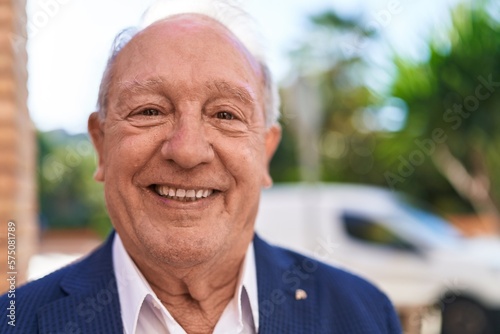 Middle age grey-haired man smiling confident standing at street