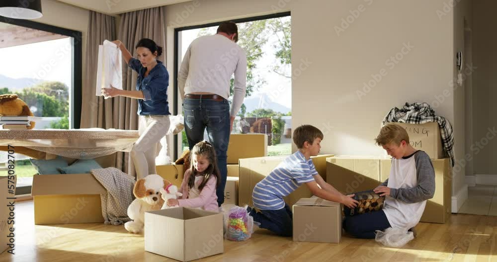 Happy, excited and carefree homeowners unpacking boxes after moving house, relocating or buying a home. Parents and children bonding together as family in their new property or real estate investment