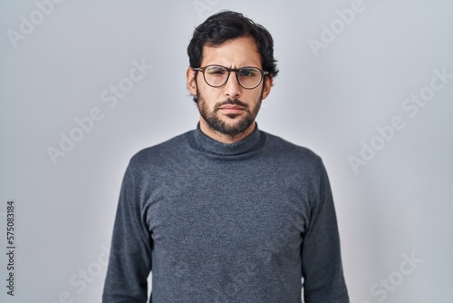 Handsome latin man standing over isolated background depressed and worry for distress, crying angry and afraid. sad expression. © Krakenimages.com