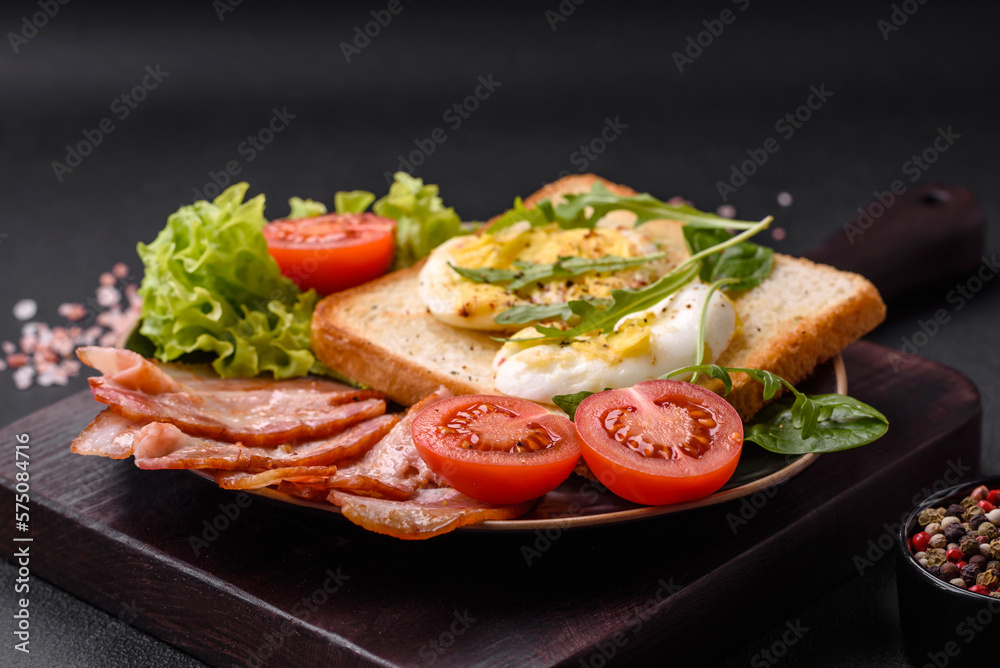 Delicious healthy lunch consisting of bacon, toast, eggs and tomatoes