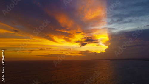 Aerial view of the sunset in an orange sky with clouds. Beautiful background for tourism and advertising. Tropical coast