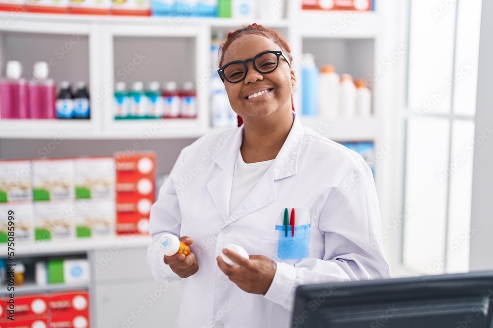African american woman pharmacist holding pills bottles at pharmacy