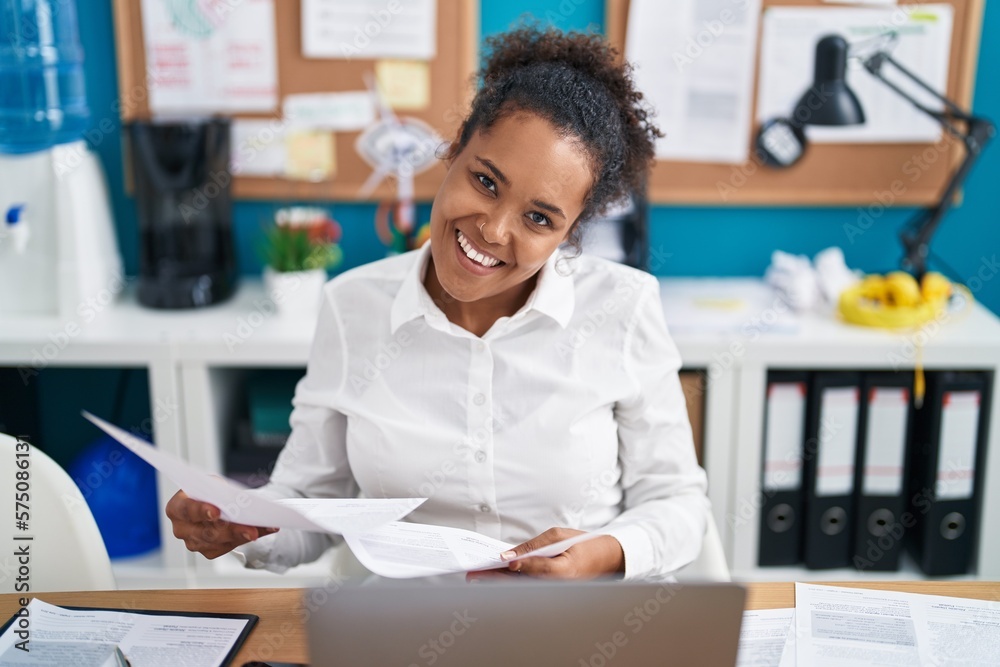 African american woman business worker using laptop reading document at office African american woman business worker using laptop reading document at office