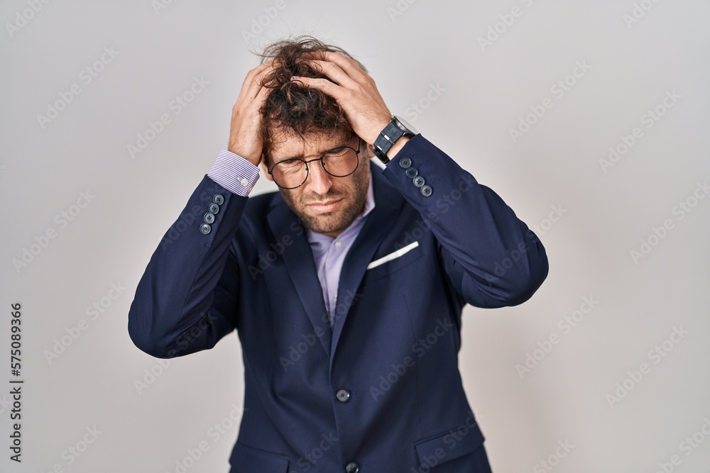 Hispanic business man wearing glasses suffering from headache desperate and stressed because pain and migraine. hands on head. Hispanic business man wearing glasses suffering from headache desperate and stressed because pain and migraine. hands on head.