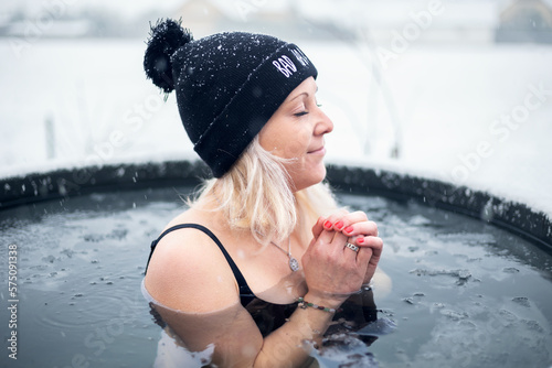 Girl is hardening by cold water during snowing