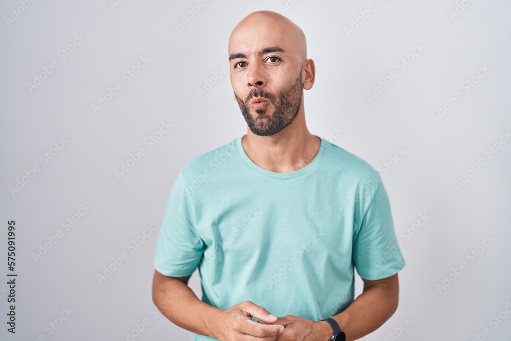 Middle age bald man standing over white background making fish face with lips, crazy and comical gesture. funny expression. Middle age bald man standing over white background making fish face with lips, crazy and comical gesture. funny expression.