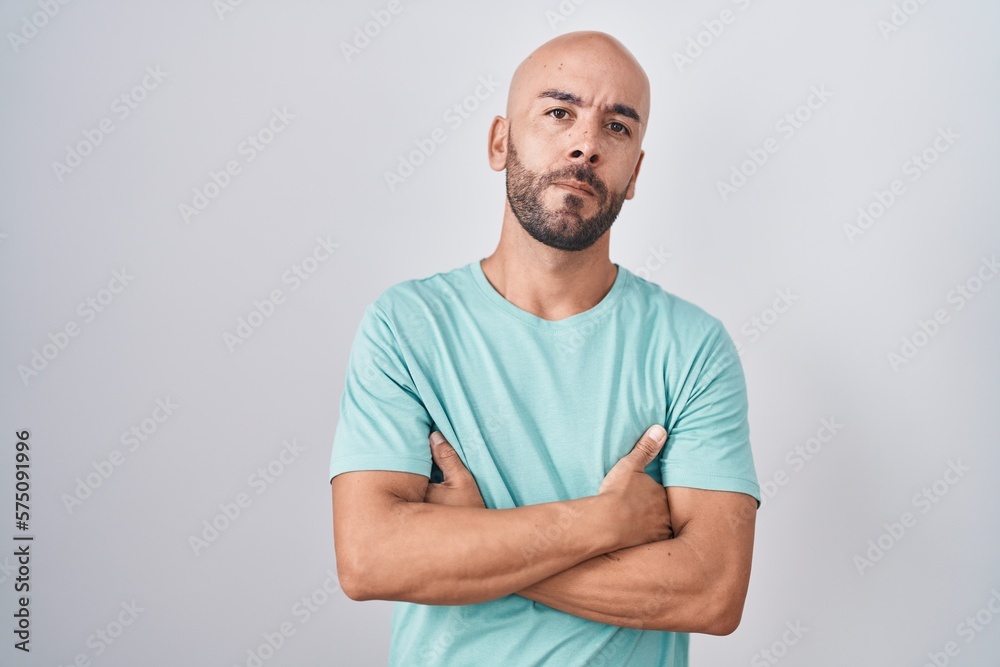 Middle age bald man standing over white background skeptic and nervous, disapproving expression on face with crossed arms. negative person. Middle age bald man standing over white background skeptic and nervous, disapproving expression on face with crossed arms. negative person.