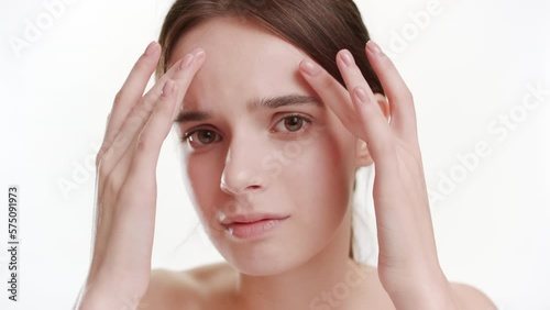 Wallpaper Mural Anti-blackheads concept | Close-up shot of cute young slim Caucasian woman with long brown hair touches her forehead and finds some skin problems disappointing on white background Torontodigital.ca