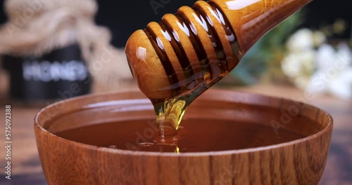 Honey spoon coming out of the bowl full of honey. Honey contains many nutrients, antioxidants, improves heart health, wound care, offers antidepressant and anti-anxiety benefits. 4k