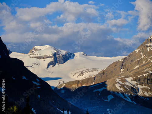 First morning light strikes the mountain peaks surrounding Peyto Lake in the Canadian Rockies and Yoho National Park