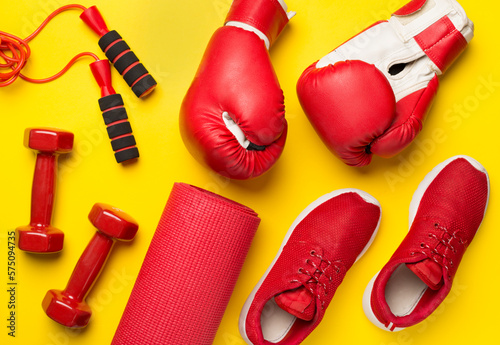 Red sport equipment on color background, top view