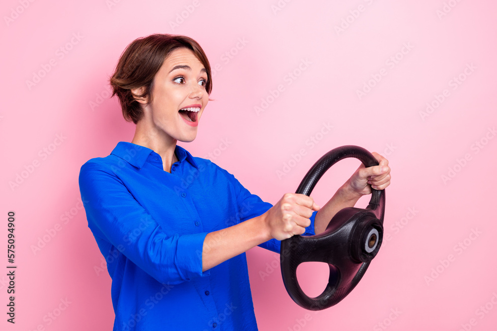 Photo of young businesswoman bob brown hair hold steering fast speed after qualitification exam driving license isolated on pink color background Photo of young businesswoman bob brown hair hold steering fast speed after qualitification exam driving license isolated on pink color background