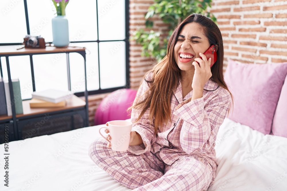 Young beautiful arab woman talking on smartphone drinking coffee at bedroom Young beautiful arab woman talking on smartphone drinking coffee at bedroom