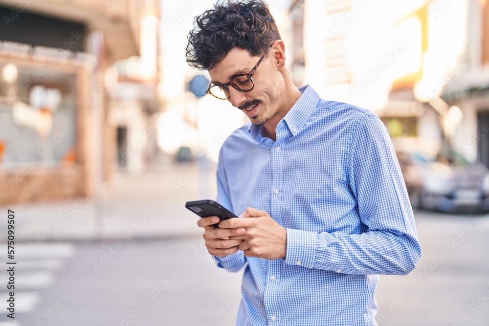 Young caucasian man smiling confident using smartphone at street
