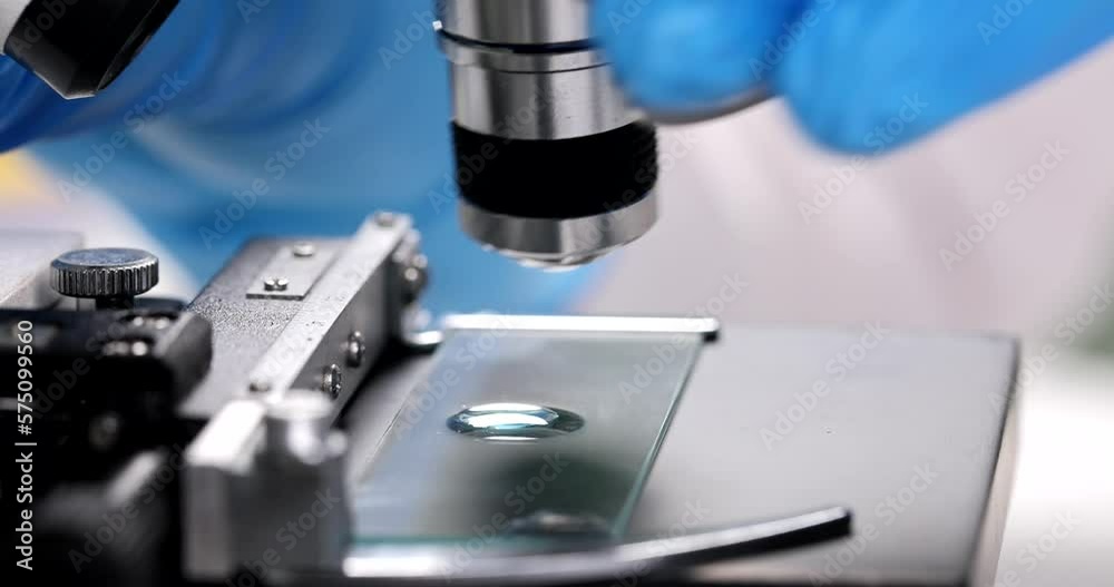 Scientist doses drop with pipette for closeup examination under microscope Scientist doses drop with pipette for closeup examination under microscope