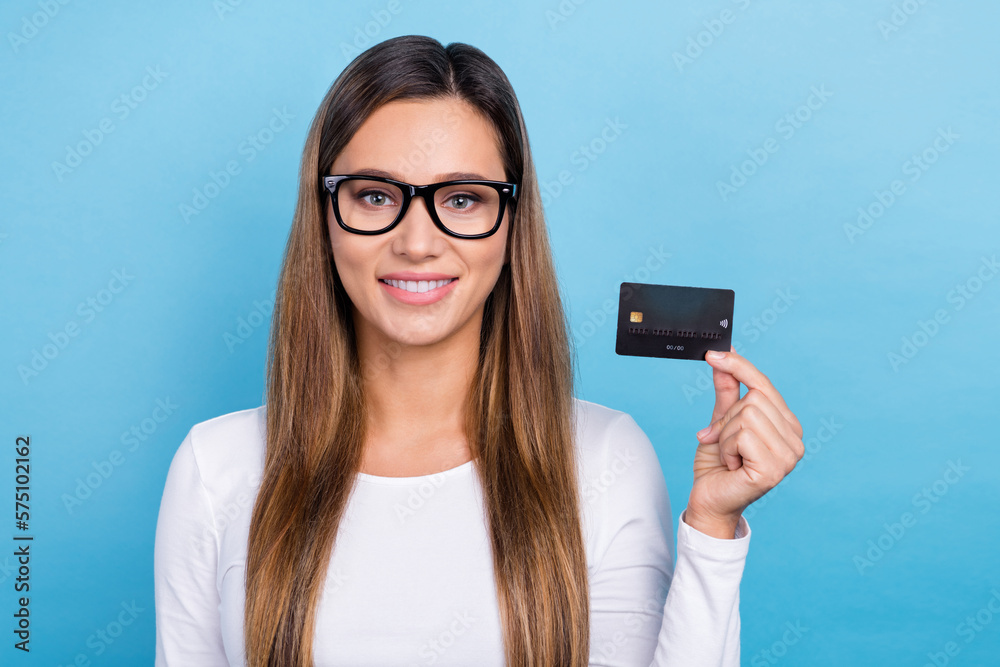 Photo of gorgeous successful glad lady wear white trendy clothes showing bank card nfc function isolated on blue color background Photo of gorgeous successful glad lady wear white trendy clothes showing bank card nfc function isolated on blue color background