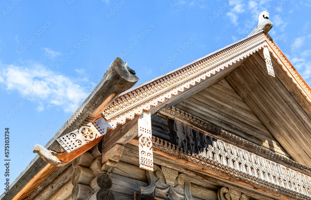 Traditional wooden handmade carved decorations on the roof of a wooden log house