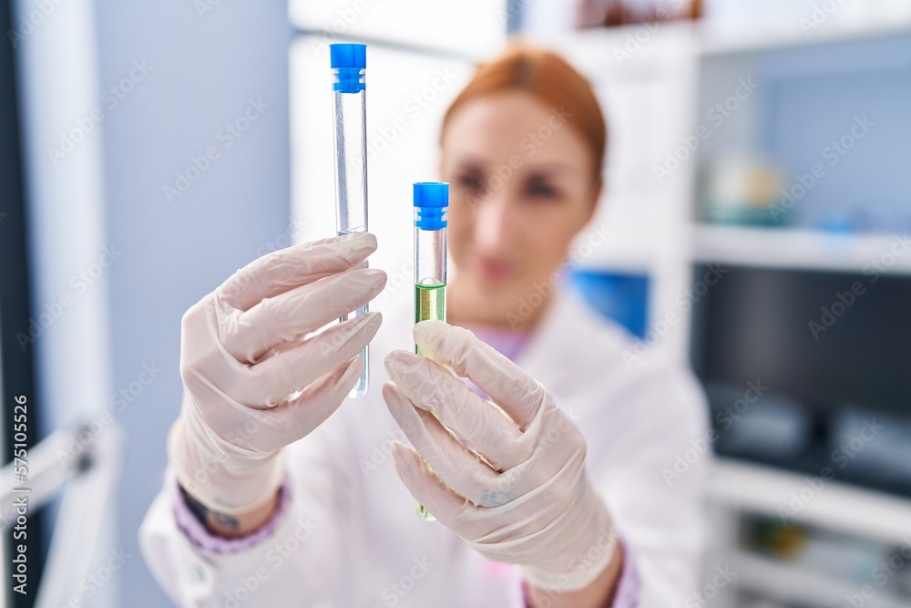 Young caucasian woman scientist measuring liquid holding test tubes at laboratory Young caucasian woman scientist measuring liquid holding test tubes at laboratory