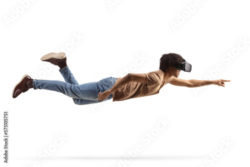 Fototapeta Naklejka Na Ścianę i Meble -  Full length shot of an african american man flying and wearing a vr headset