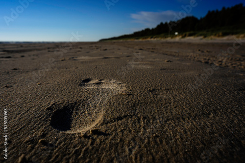 A lonely human footprint in beach sand on a calm and windless evening