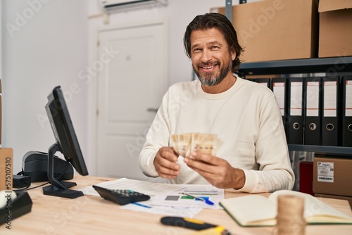 Middle age man ecommerce business worker counting denmark kroner banknotes at office
