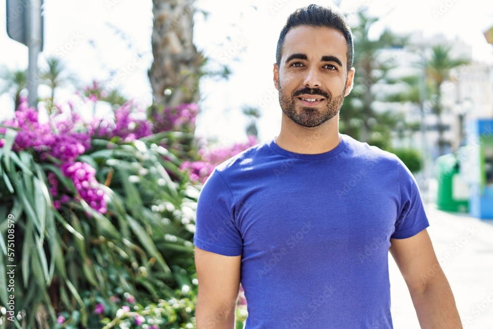 Young hispanic man smiling confident walking at street