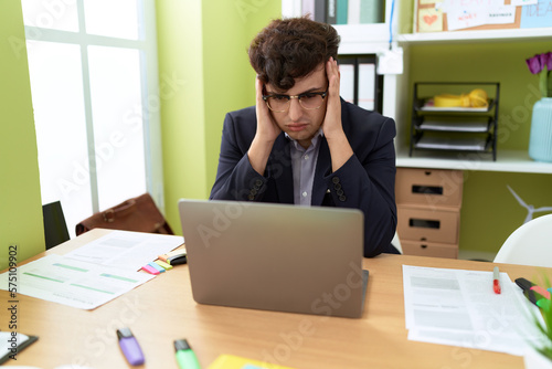 Non binary man business worker stressed using laptop at office
