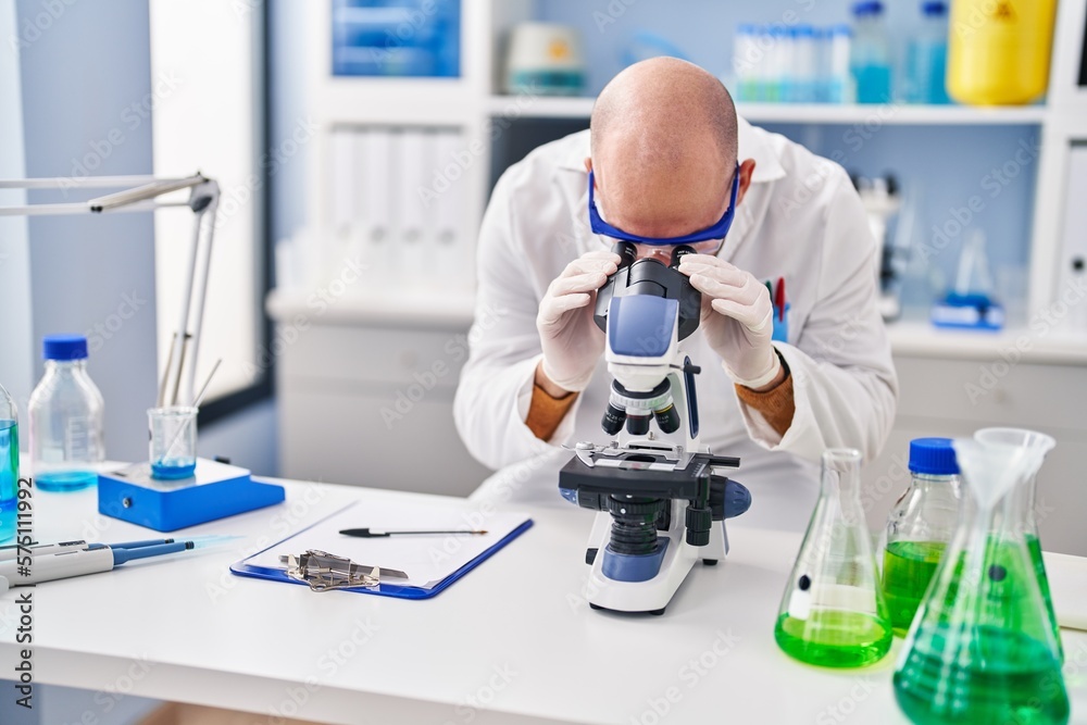 Young man scientist using microscope at laboratory Young man scientist using microscope at laboratory