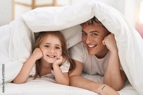 Father and daughter father and daughter lying on bed covering with bedsheet at bedroom
