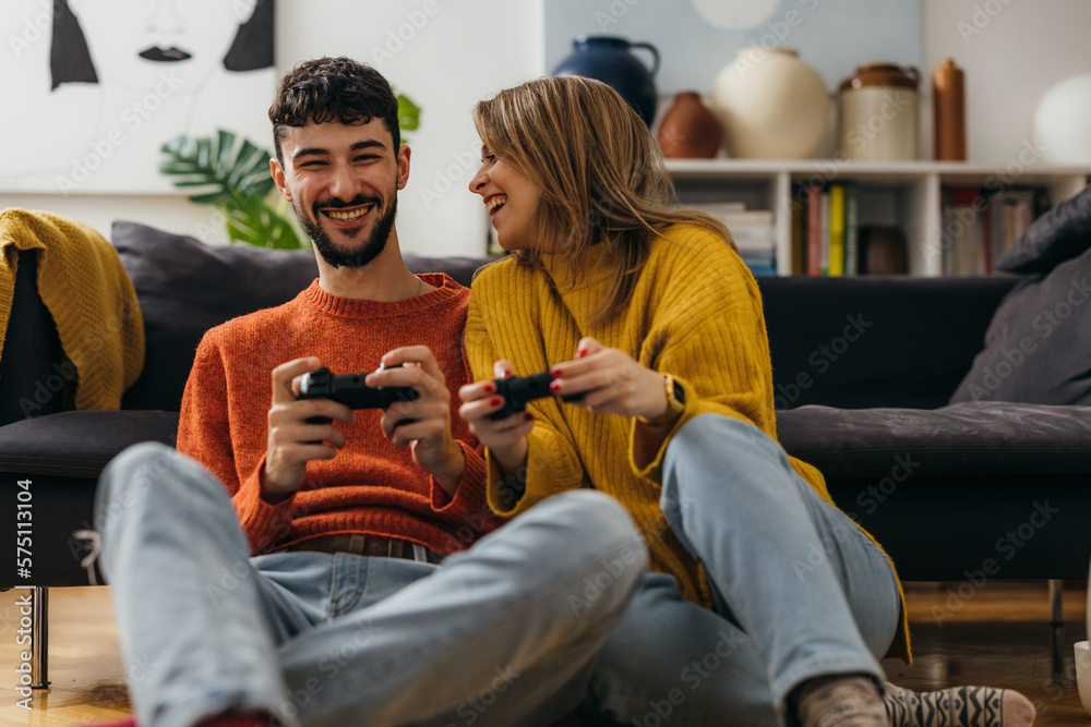 Joyful woman and man are playing video games at home