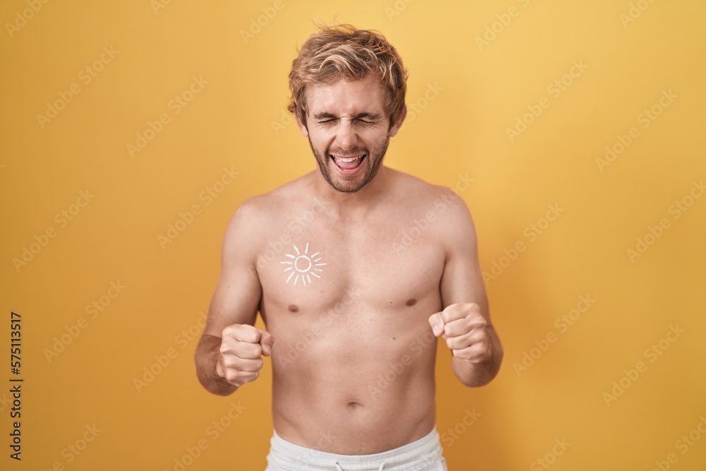 Caucasian man standing shirtless wearing sun screen excited for success with arms raised and eyes closed celebrating victory smiling. winner concept.