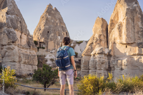 Man tourist on background of Unique geological formations in Love Valley in Cappadocia, popular travel destination in Turkey