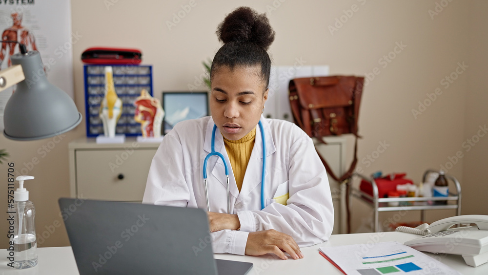 Young african american woman doctor using laptop working at clinic Young african american woman doctor using laptop working at clinic