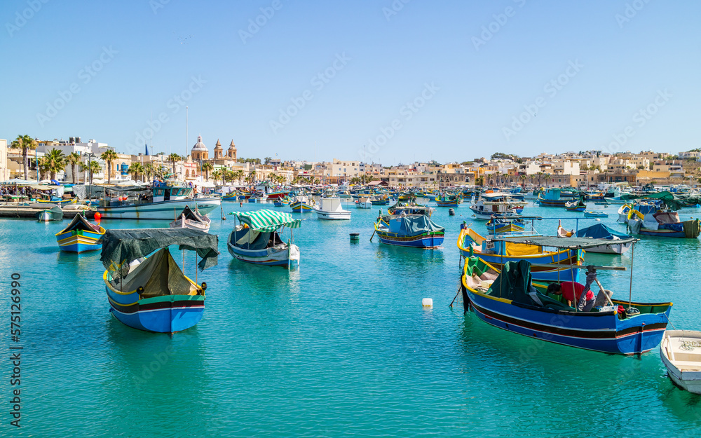 Boats on turquoise sea in bay near Marsaxlokk, Malta