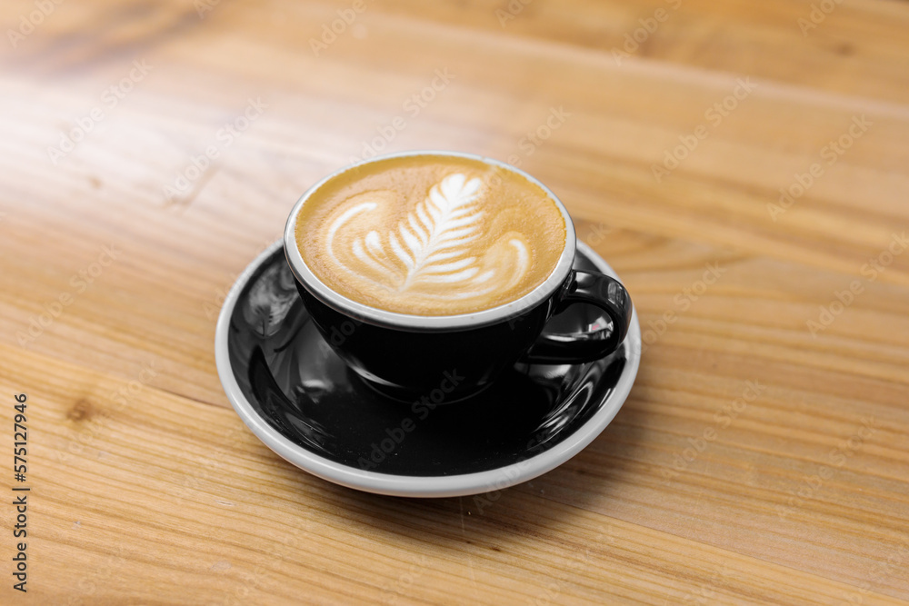 Obraz premium Coffee in a black cup on a wooden table