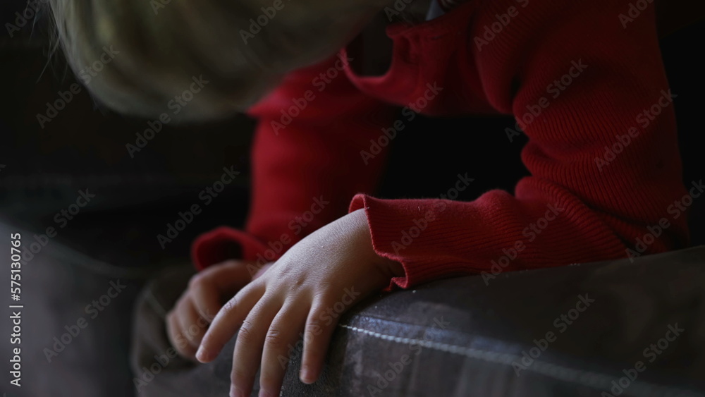 Young boy watching media cartoon off camera while chewing food with hand in chin