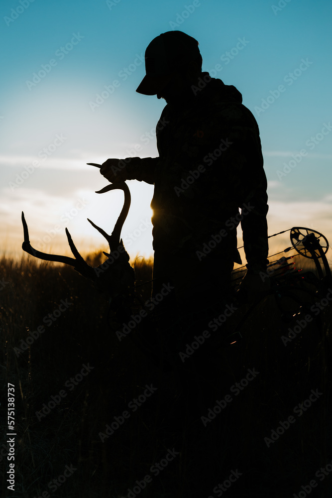 silhouette of a bow hunter with antlers