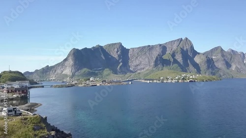 Aerial shot over a road, cars and bridge towards mountains in Lofoten, Norway