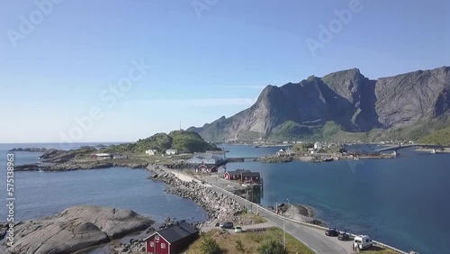 Aerial shot over a road, cars and bridge towards mountains in Lofoten, Norway