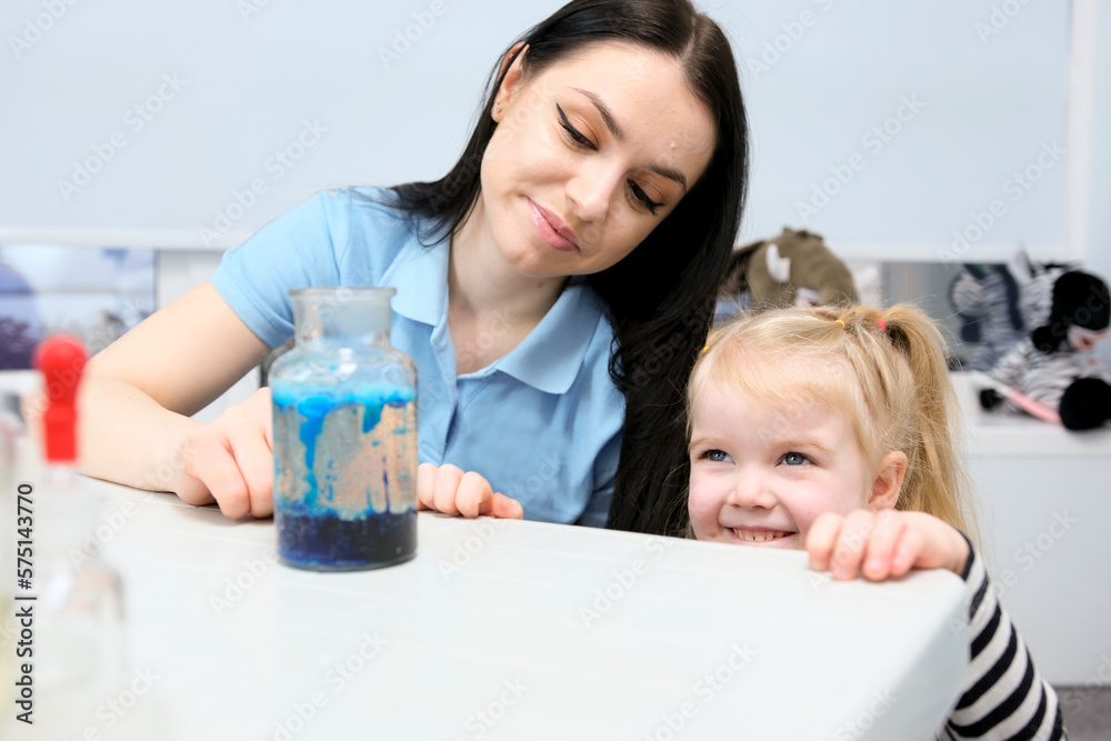 Little scientist. Curious daughter play with mom engaged at education activity make funny experiment. Interested small girl watch elder sister doing chemical test use chemistry set kids Little scientist. Curious daughter play with mom engaged at education activity make funny experiment. Interested small girl watch elder sister doing chemical test use chemistry set kids