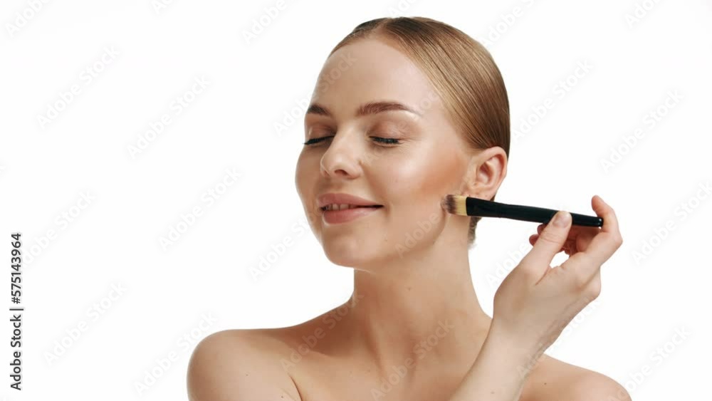 Lovely woman smiles and holds a make-up brush near her face. Natural makeup. Professional make-up artist. Lovely woman smiles and holds a make-up brush near her face. Natural makeup. Professional make-up artist.