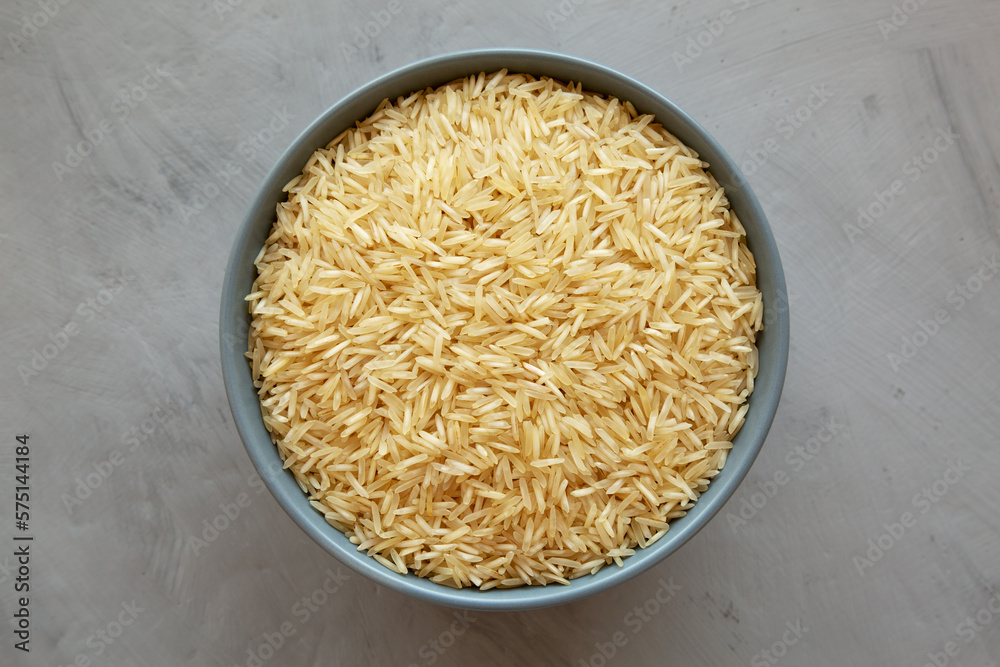 Dry Organic Indian Basmati Rice in a Bowl on a gray background, top view. Flat lay, overhead, from above. Dry Organic Indian Basmati Rice in a Bowl on a gray background, top view. Flat lay, overhead, from above.