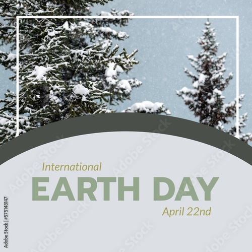 Image of international earth day text over fir tree forest in snow